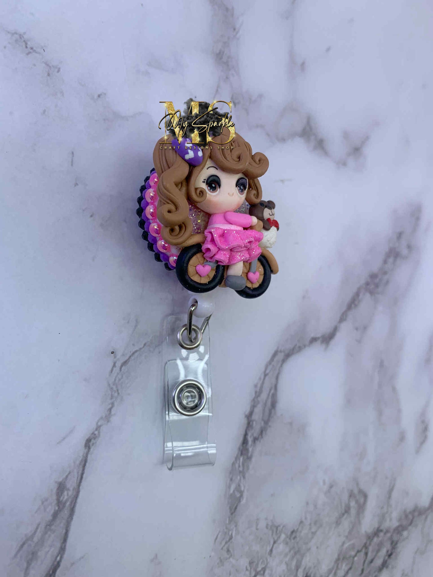 Girl Riding Bike Clay Badge Reel